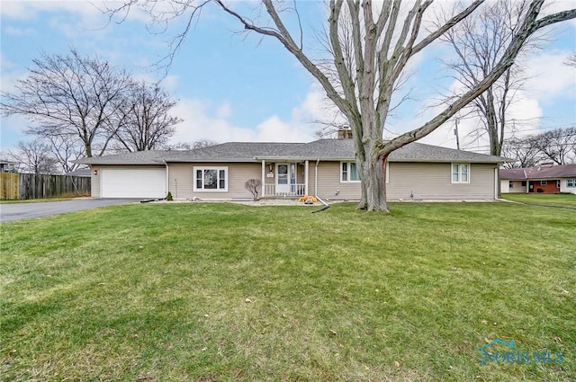 ranch-style house featuring covered porch, a garage, and a front lawn