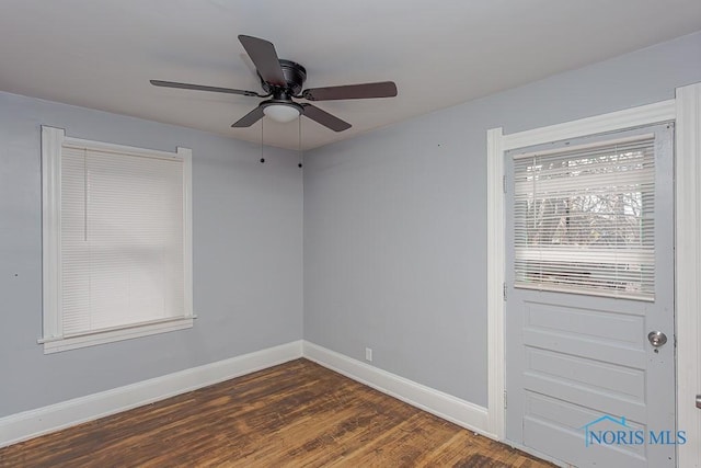 empty room with dark hardwood / wood-style floors and ceiling fan