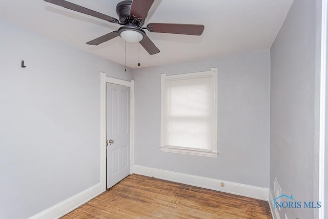 empty room with hardwood / wood-style floors and ceiling fan