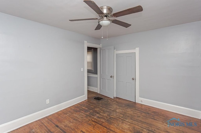 spare room featuring ceiling fan and dark wood-type flooring