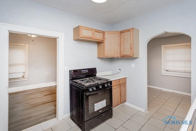 kitchen featuring black gas stove, light hardwood / wood-style flooring, and light brown cabinetry