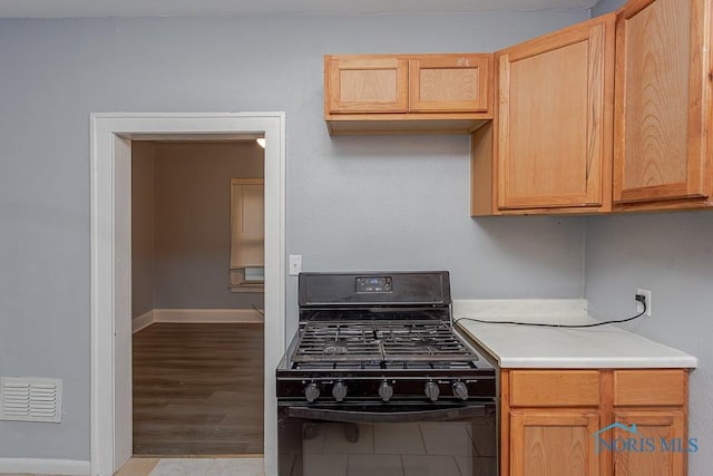 kitchen featuring black range with gas stovetop, light hardwood / wood-style floors, and light brown cabinetry