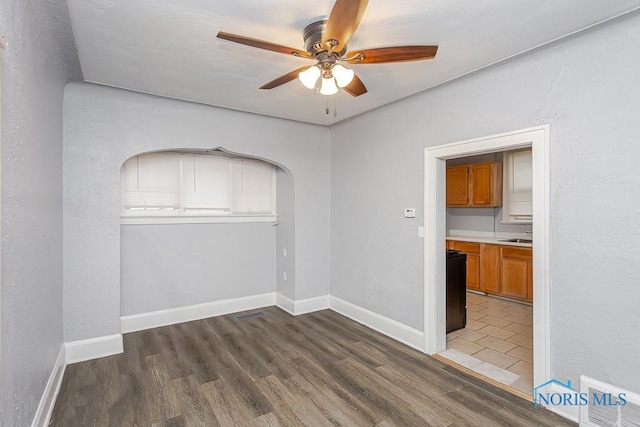 spare room featuring ceiling fan and dark wood-type flooring