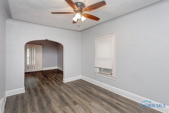 spare room featuring ceiling fan and dark wood-type flooring