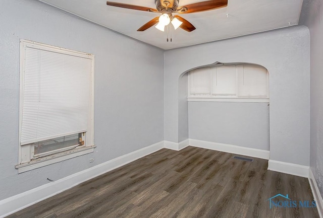 empty room with ceiling fan and dark wood-type flooring