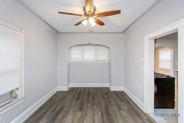 empty room with ceiling fan and dark hardwood / wood-style flooring