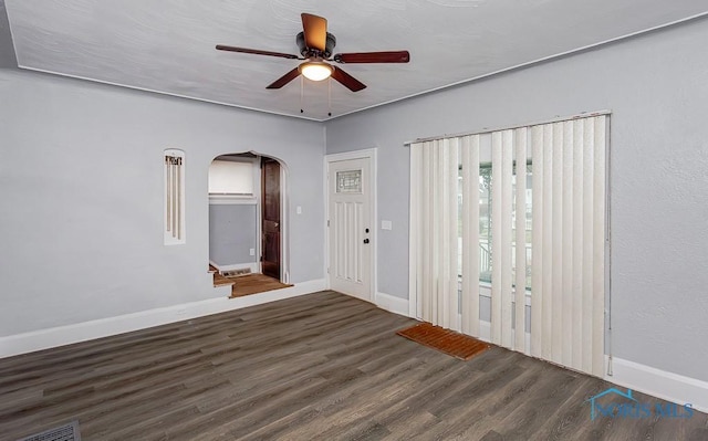 empty room with dark hardwood / wood-style floors and ceiling fan