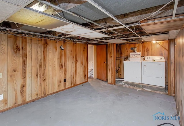 basement with washer and dryer and wooden walls