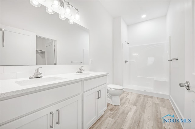 211 E Bridge Rd, Northwood, OH 43619 - bathroom with toilet, vanity, wood-type flooring, and walk in shower