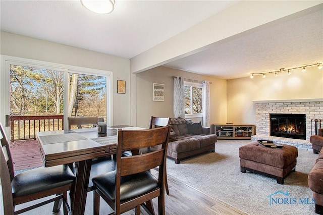 dining room with a fireplace, beamed ceiling, and hardwood / wood-style floors