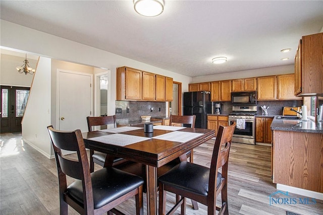 dining area with french doors, hardwood / wood-style flooring, an inviting chandelier, and sink