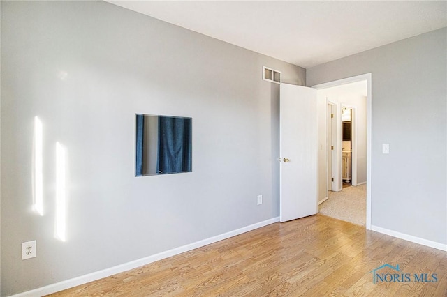 empty room with light hardwood / wood-style flooring