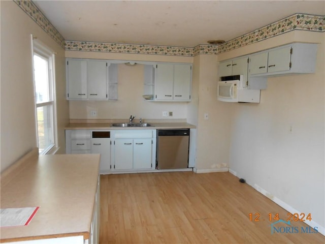 kitchen with light hardwood / wood-style flooring, stainless steel dishwasher, white cabinetry, and sink