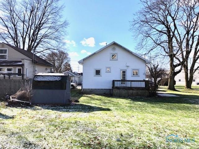 rear view of property featuring a yard and a wooden deck