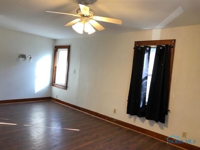 spare room featuring ceiling fan and dark wood-type flooring