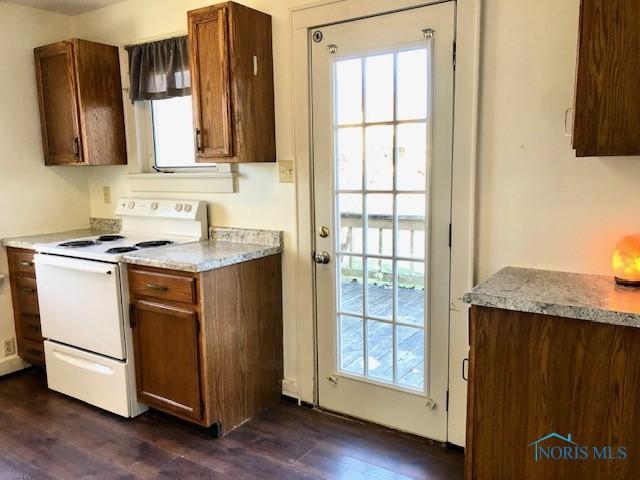 kitchen with electric range and dark hardwood / wood-style flooring