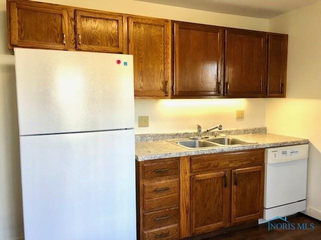 kitchen featuring dark hardwood / wood-style flooring, white appliances, and sink