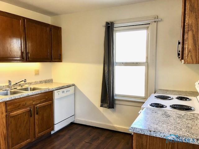 kitchen featuring sink, dark wood-type flooring, and white appliances