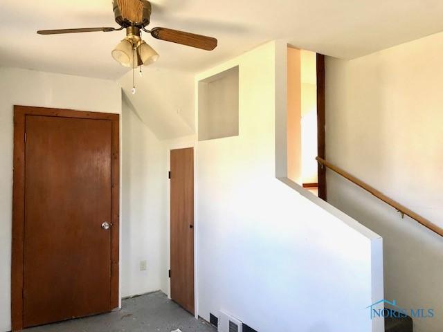 stairs featuring ceiling fan and concrete floors