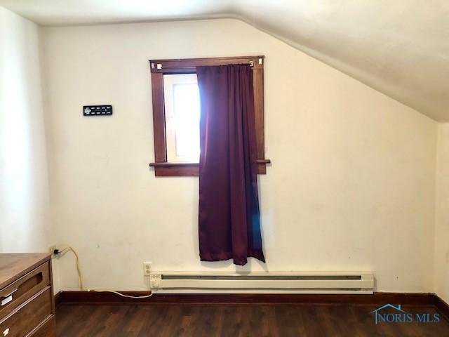 bonus room with dark hardwood / wood-style flooring, a baseboard radiator, and lofted ceiling