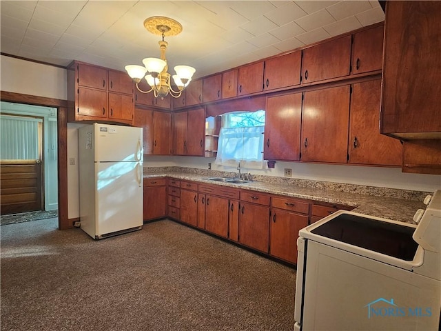 kitchen featuring sink, hanging light fixtures, stove, white fridge, and a chandelier