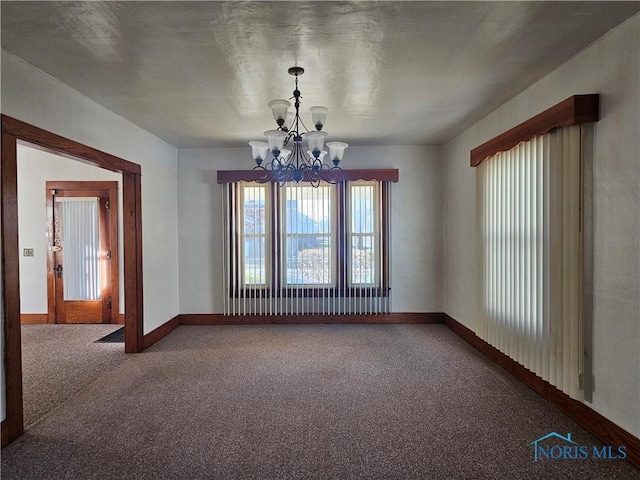 carpeted empty room with an inviting chandelier