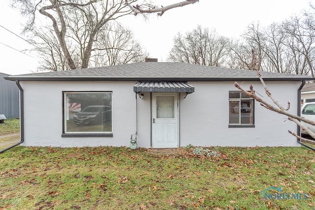 single story home featuring a front lawn