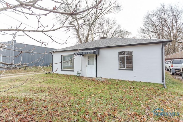 rear view of property featuring a lawn