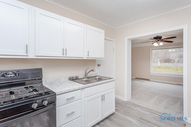 kitchen with ceiling fan, black stove, white cabinets, and sink