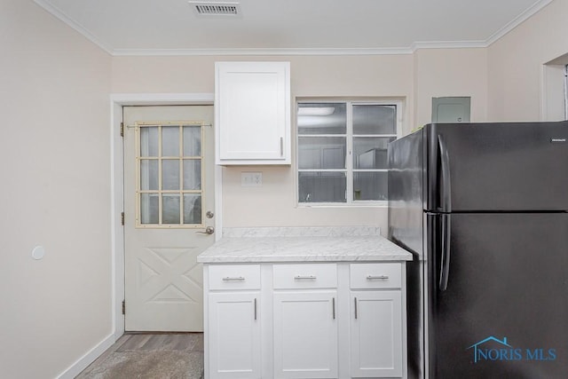 kitchen featuring white cabinets, hardwood / wood-style floors, fridge, and crown molding