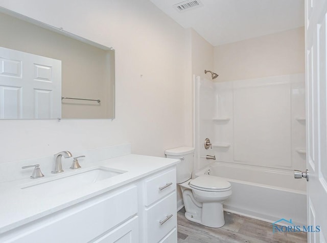 full bathroom featuring vanity, wood-type flooring, shower / bathtub combination, and toilet