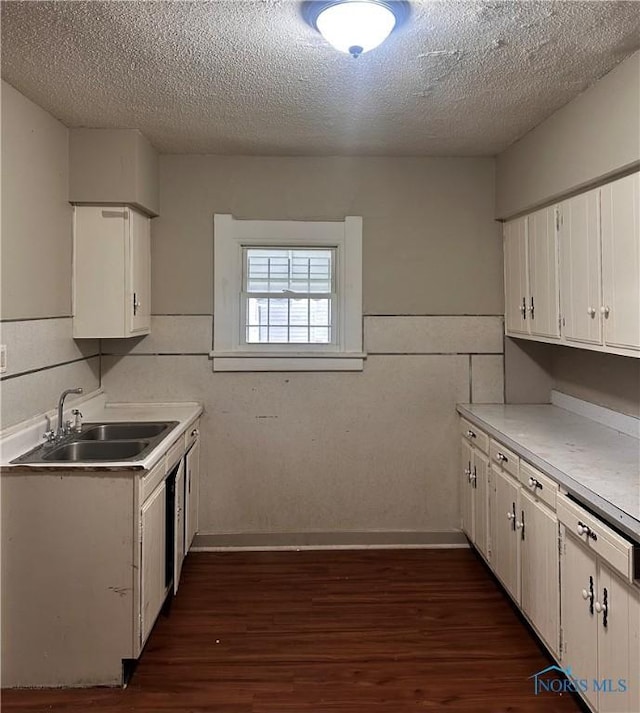 kitchen featuring white cabinets, dark hardwood / wood-style flooring, sink, and a textured ceiling