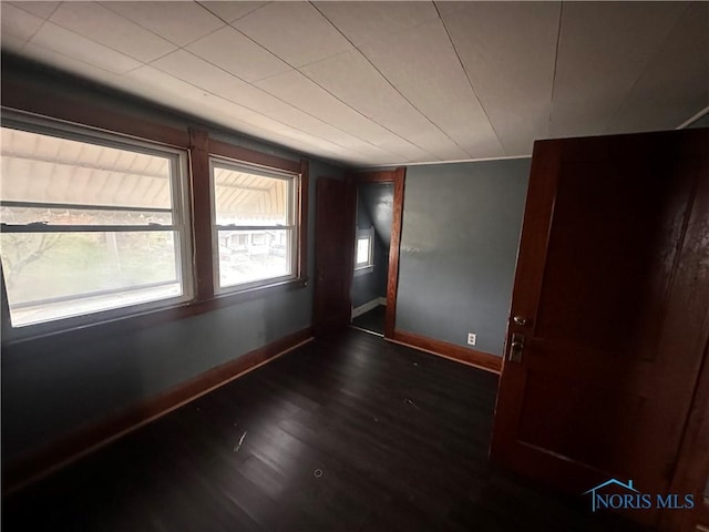 spare room with dark wood-type flooring