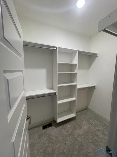 walk in closet featuring dark colored carpet and visible vents