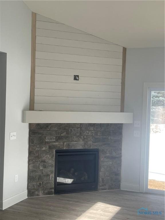 interior details with a fireplace, baseboards, and wood finished floors