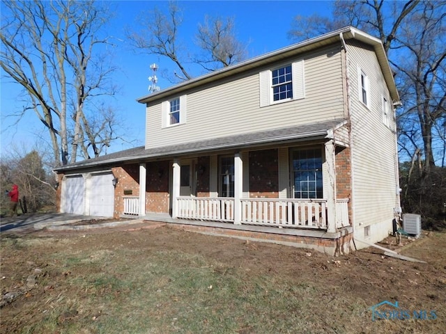 view of front facade with covered porch, central AC, and a garage