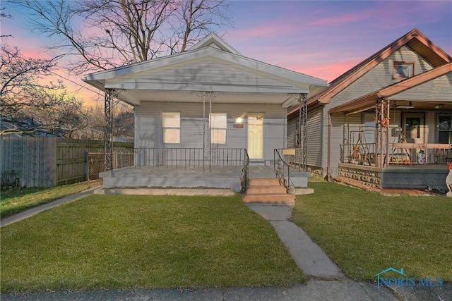 bungalow-style home featuring a porch and a yard