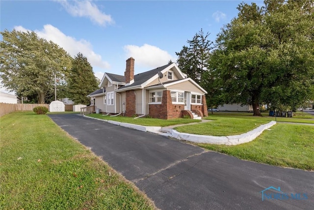 view of front of house with a front yard and a storage unit