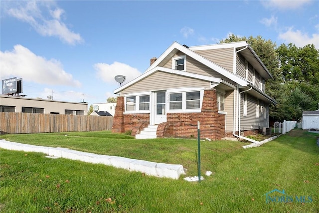 view of front facade featuring a front yard and cooling unit