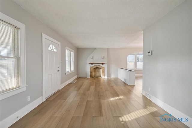 unfurnished living room with light hardwood / wood-style floors and a wealth of natural light