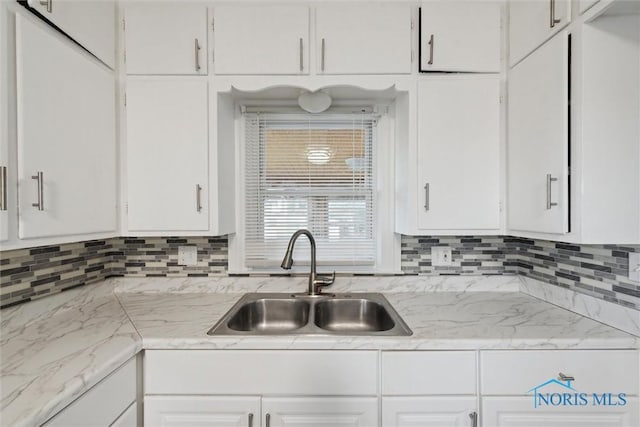 kitchen with white cabinetry, sink, and tasteful backsplash