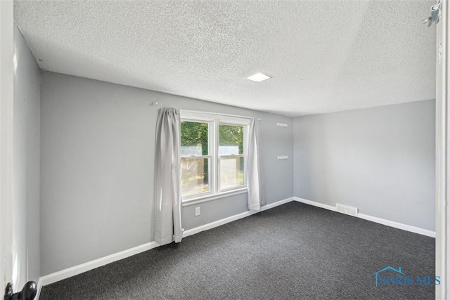 carpeted spare room featuring a textured ceiling