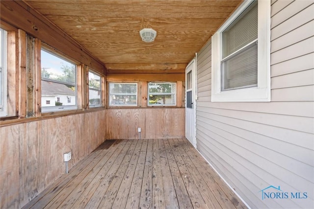 unfurnished sunroom with a healthy amount of sunlight and wooden ceiling