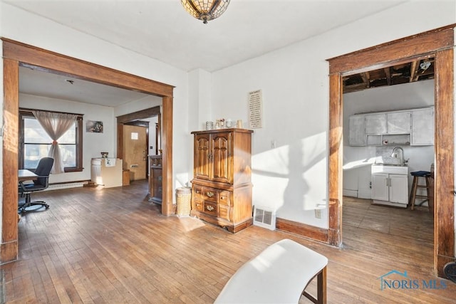 office with hardwood / wood-style floors and sink