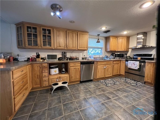 kitchen with sink, wall chimney exhaust hood, decorative light fixtures, a textured ceiling, and appliances with stainless steel finishes