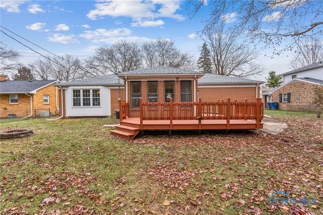 rear view of house featuring a deck and an outdoor fire pit