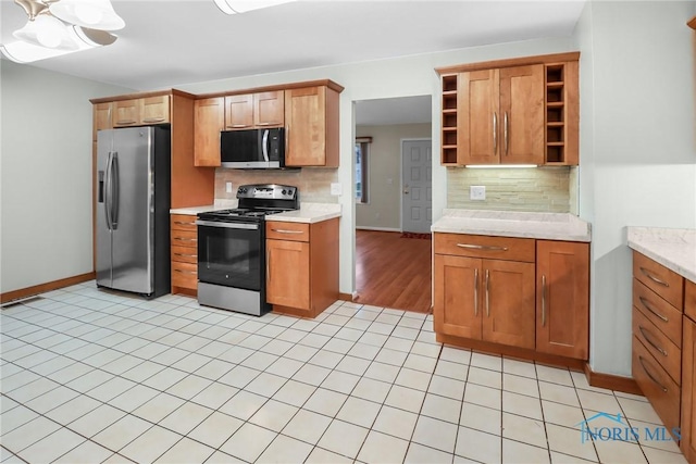 kitchen with light tile patterned floors, stainless steel appliances, and tasteful backsplash