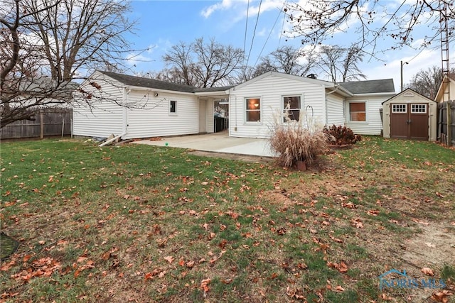 rear view of property with a shed, a yard, and a patio