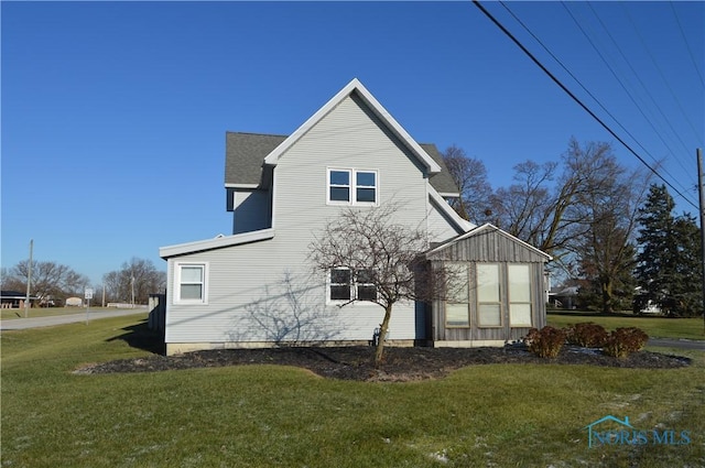 view of side of home with a lawn