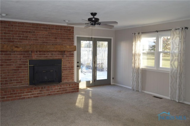 unfurnished living room with carpet, a brick fireplace, ceiling fan, and ornamental molding